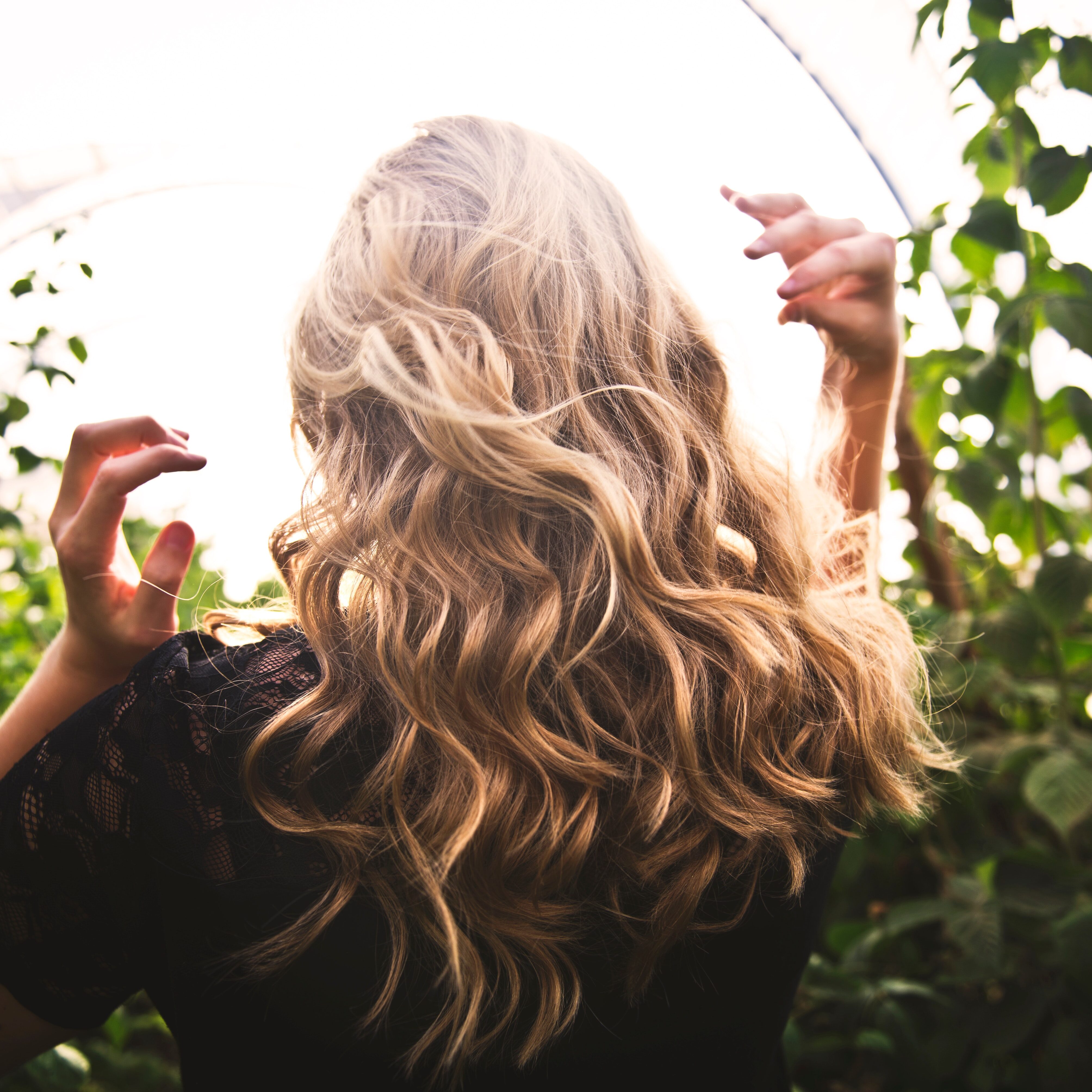 blonde-haired-woman-standing-between-green-plants-1049687